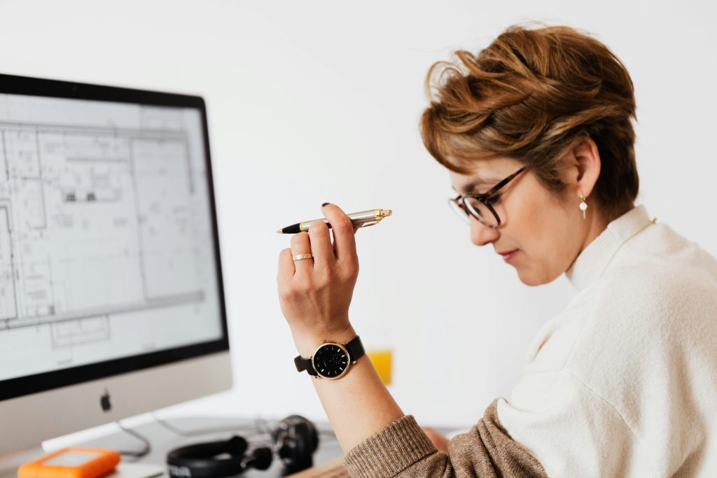 Architect reviewing blueprint on computer screen