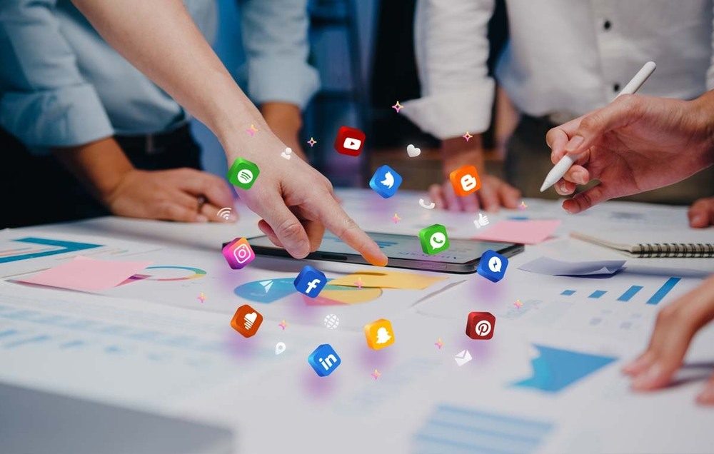 Team analyzing a social media content strategy with icons hovering over a digital tablet.